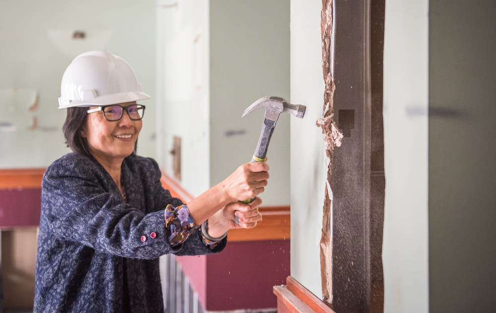 Yeh takes a ceremonial swing at the wall inside Hale Library’s southeast entrance. Photo courtesy of Kansas State.