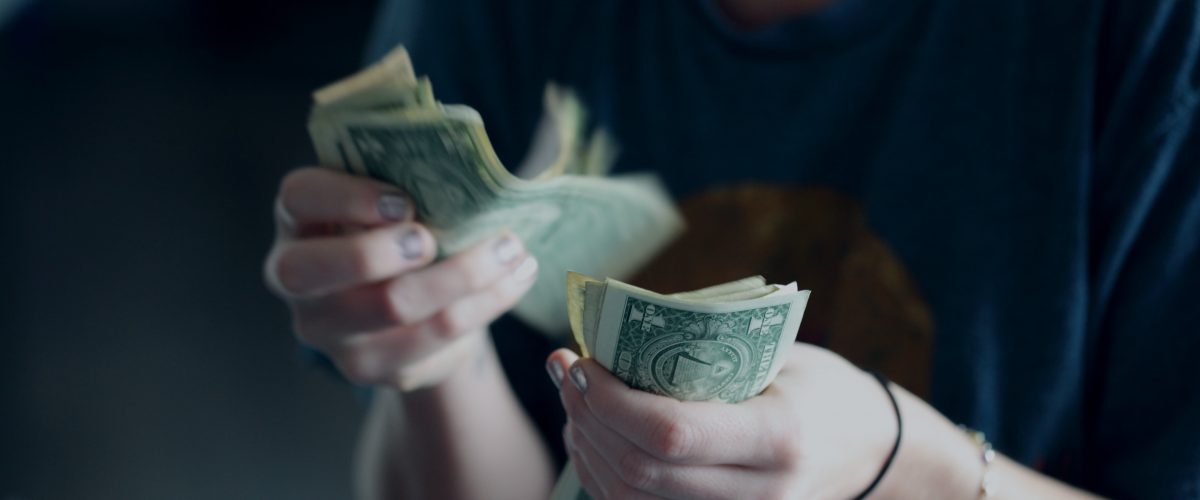 Woman's hands counting dollar bills