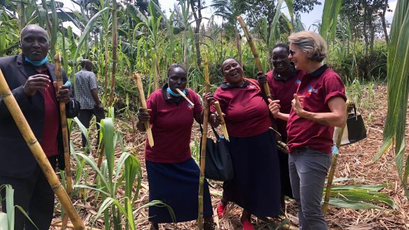 Student Mimi Stockton studying sustainable management in Kenya with people in sugar cane field