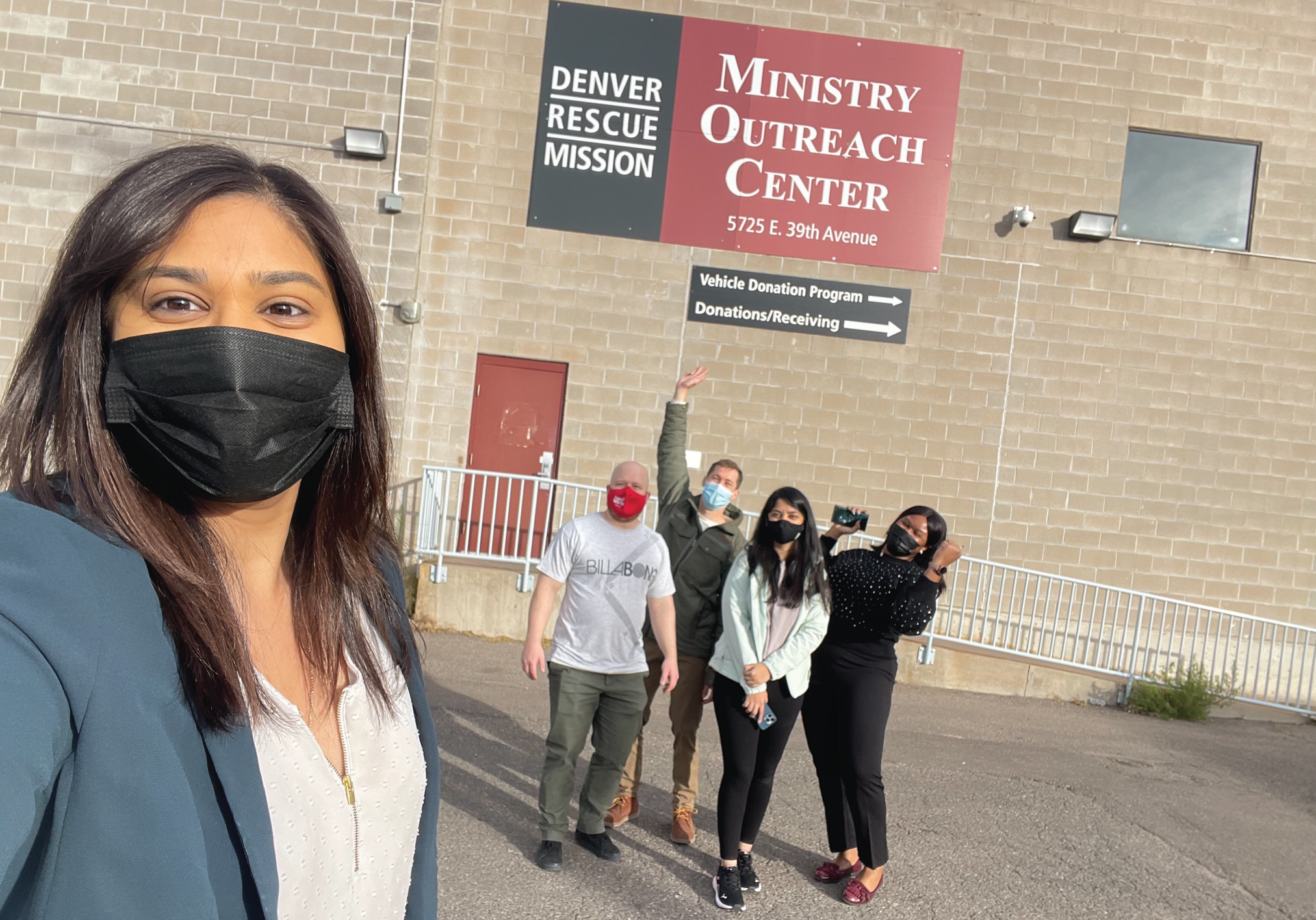 Students getting an MBA standing in-front of Denver Rescue Mission with their professor. 