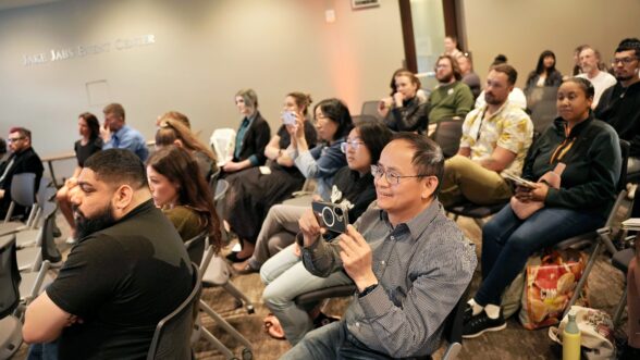 Audience seated in a conference room at the Jake Jabs Event Center, attentively watching presentations during THE CLIMB pitch competition.