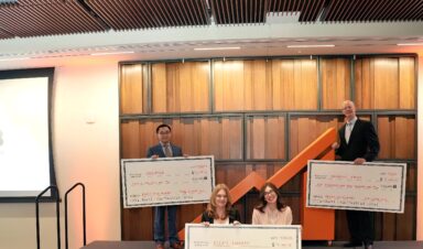 Three winning student teams pose on stage holding large award checks at THE CLIMB Pitch Night, celebrating their placements.