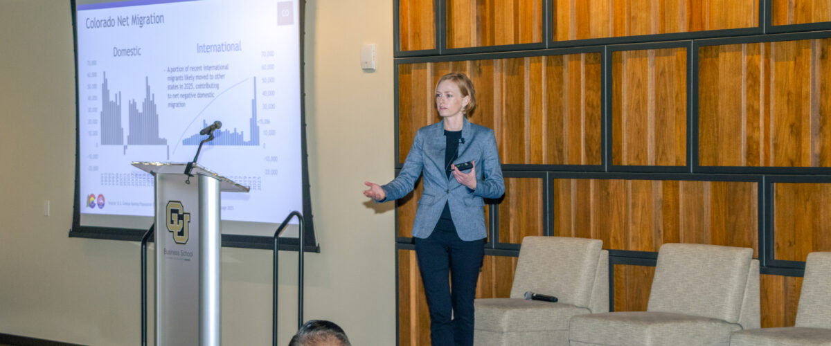 colorado state demographer kate watkins standing in a conference as she's making a presentation